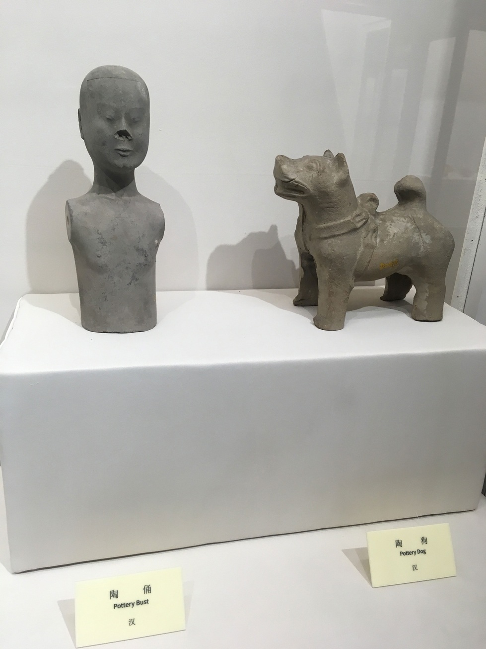 Man with no arms and dog clay statues